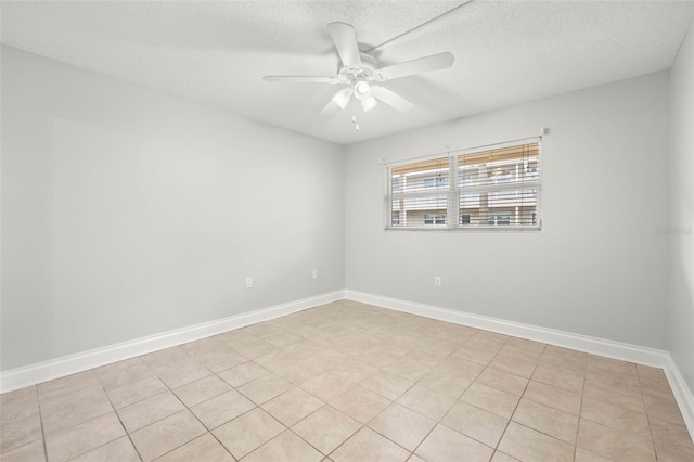 spare room with a textured ceiling, baseboards, and a ceiling fan