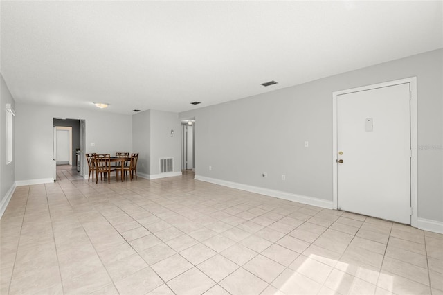 interior space featuring light tile patterned floors, baseboards, and visible vents