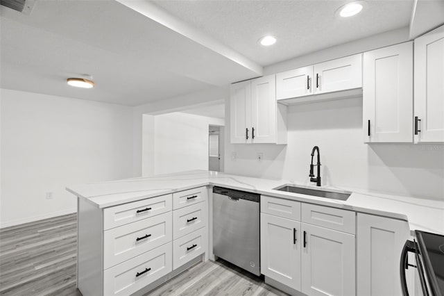 kitchen with a peninsula, stove, a sink, white cabinets, and stainless steel dishwasher