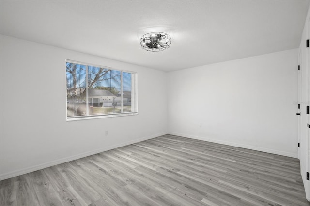 unfurnished room featuring baseboards and wood finished floors