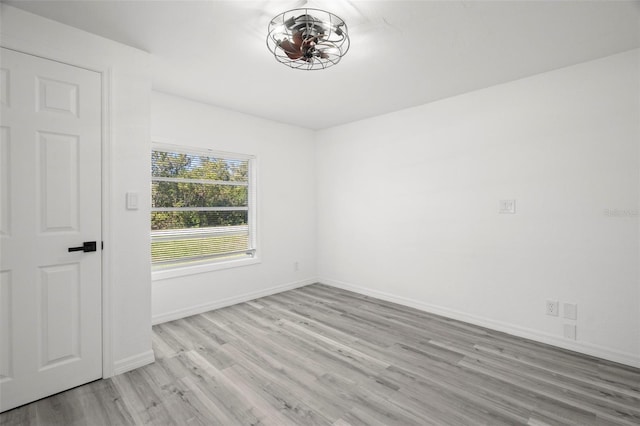 unfurnished room with light wood finished floors and baseboards