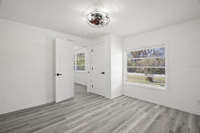 unfurnished bedroom with light wood-style flooring and baseboards