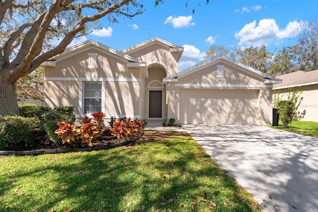 ranch-style house featuring a garage, concrete driveway, a front lawn, and stucco siding