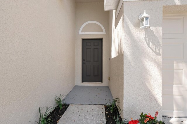 entrance to property featuring stucco siding