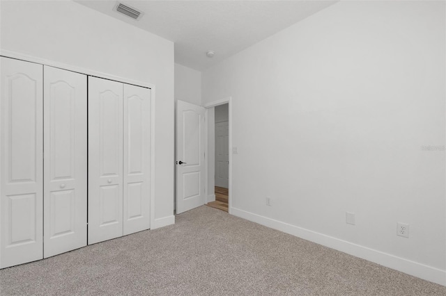 unfurnished bedroom with carpet floors, a closet, visible vents, and baseboards