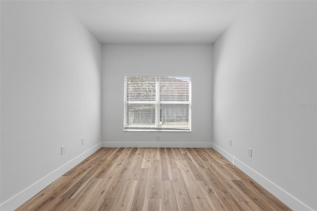 empty room with light wood-style flooring and baseboards