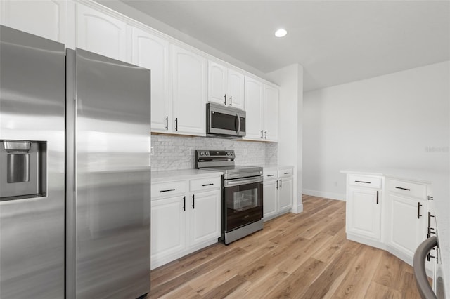 kitchen featuring white cabinetry, light countertops, appliances with stainless steel finishes, light wood finished floors, and tasteful backsplash