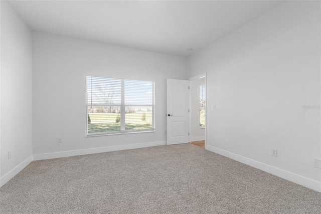 unfurnished room featuring carpet and baseboards