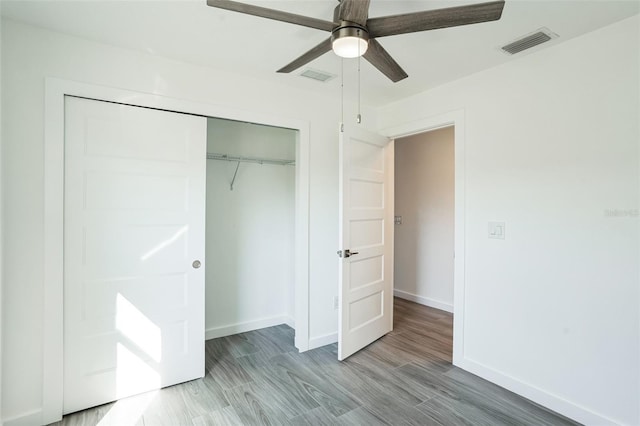 unfurnished bedroom with light wood-type flooring, baseboards, visible vents, and a closet