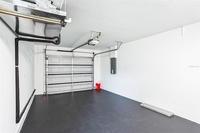 garage featuring concrete block wall, electric panel, and a garage door opener