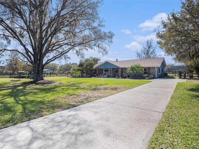 view of front of home with driveway, a front lawn, and fence