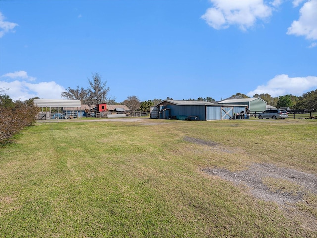 view of yard featuring a detached carport, a pole building, and an outdoor structure