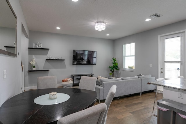 dining area with dark wood-style floors, recessed lighting, visible vents, and a textured ceiling