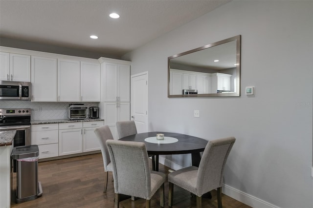 dining room featuring baseboards, dark wood-style flooring, recessed lighting, and a toaster