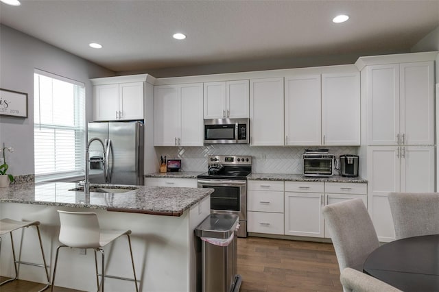 kitchen with dark wood-style floors, white cabinetry, appliances with stainless steel finishes, and a sink