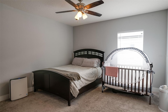 carpeted bedroom featuring a ceiling fan and baseboards