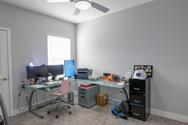 carpeted office featuring baseboards and a ceiling fan