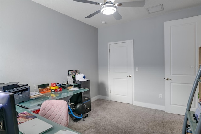 carpeted office space with ceiling fan and baseboards