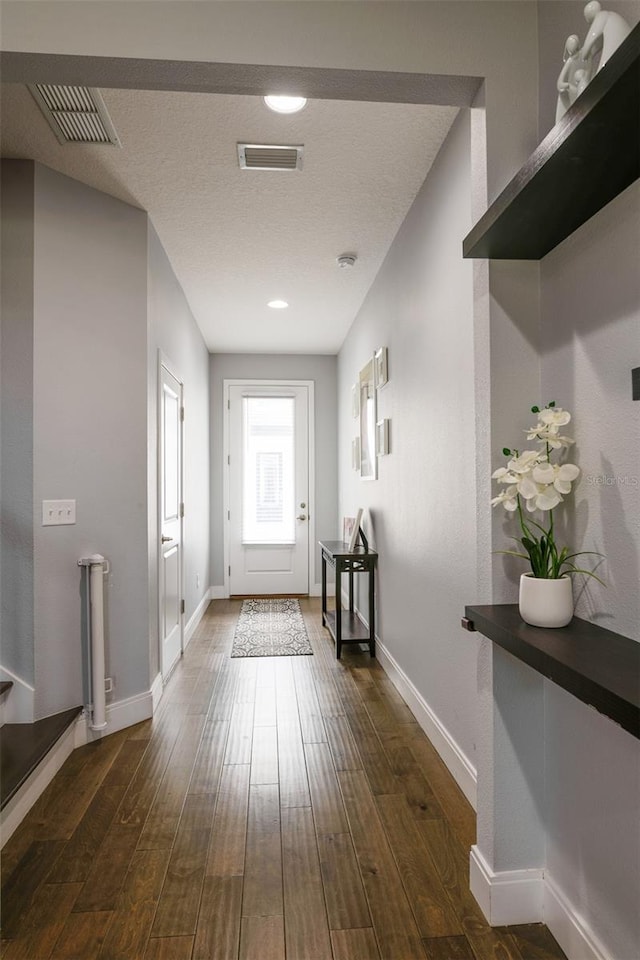 entryway featuring baseboards, visible vents, and dark wood-type flooring