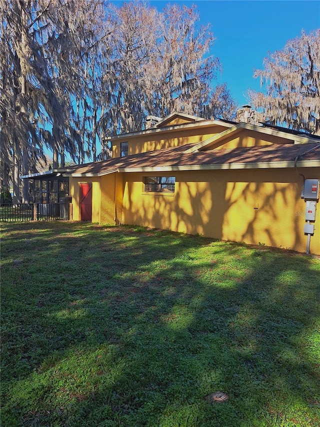 view of home's exterior featuring fence and a yard