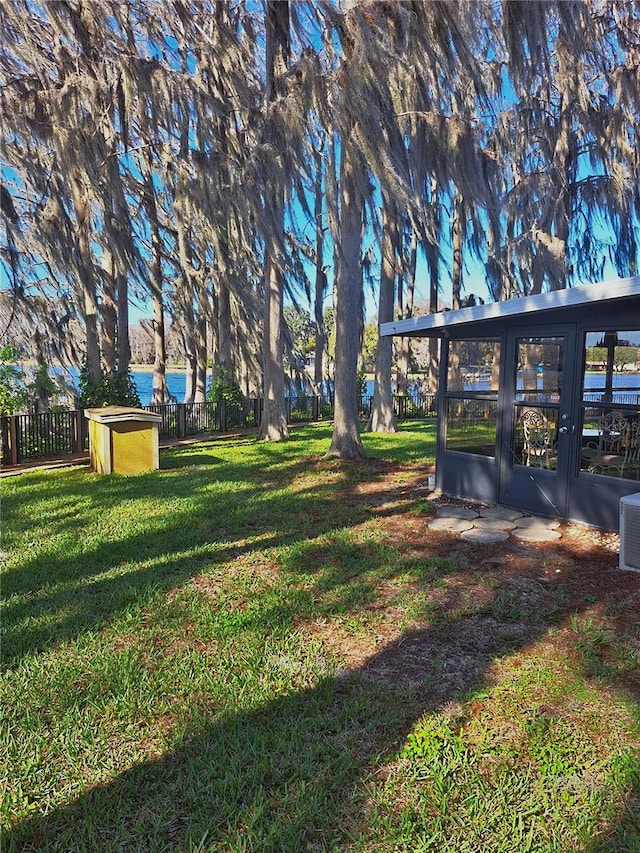 view of yard with a water view and fence