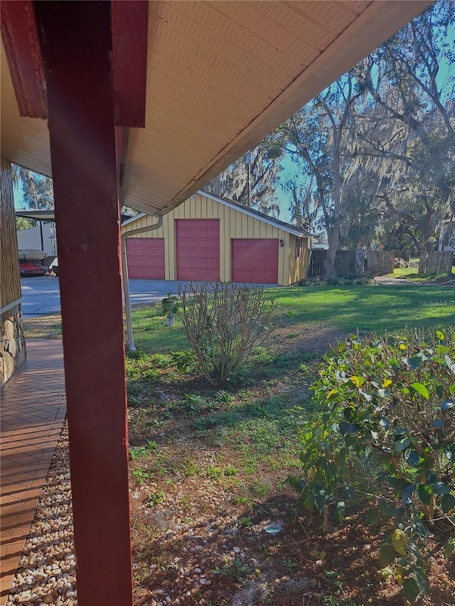 view of yard with a garage, fence, and an outdoor structure