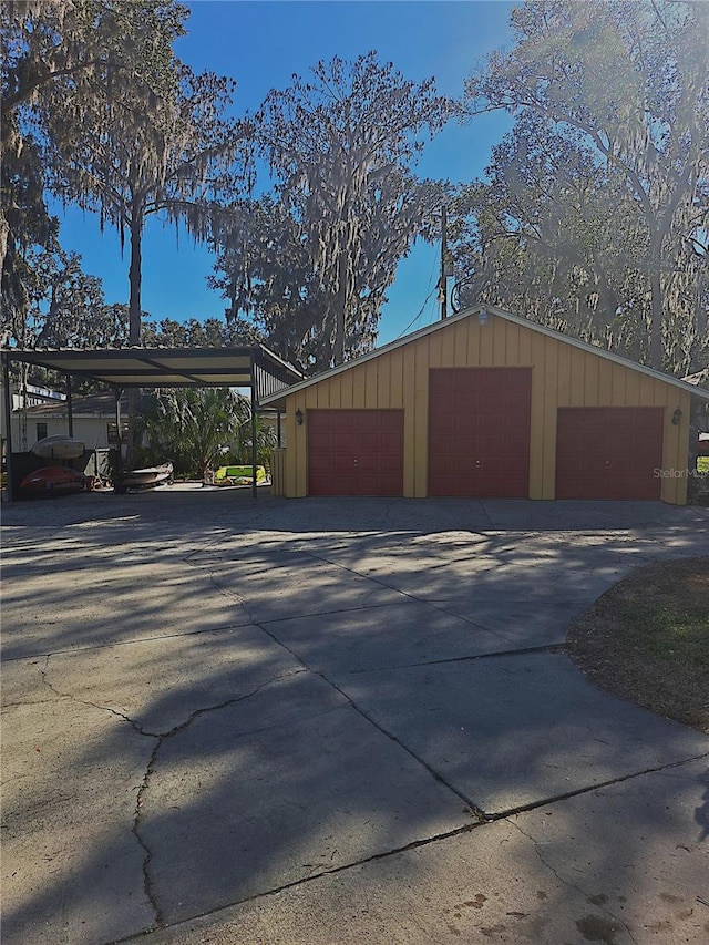 garage featuring driveway and a carport