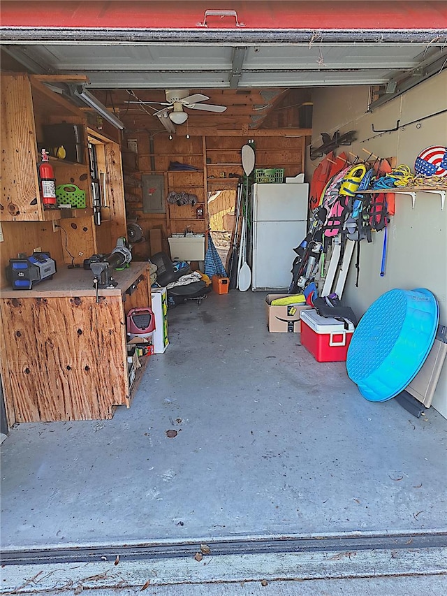 garage with freestanding refrigerator and electric panel