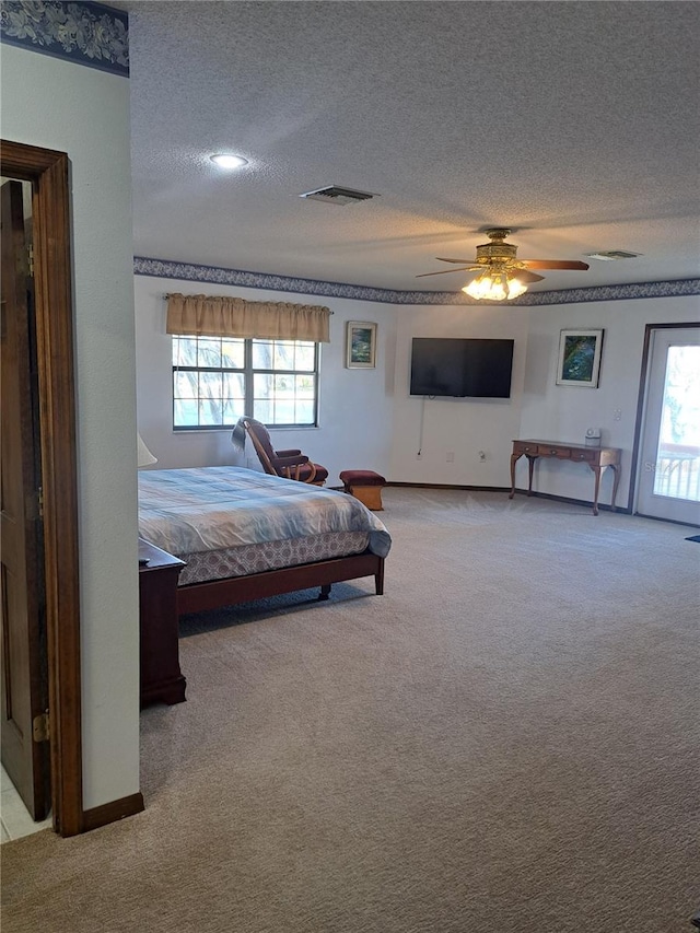 bedroom featuring light carpet, multiple windows, and a textured ceiling