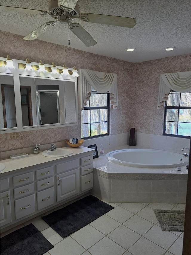 bathroom with wallpapered walls, plenty of natural light, and a textured ceiling