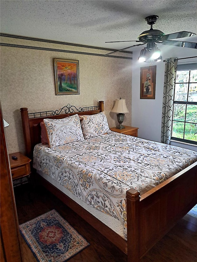 bedroom with a textured ceiling, wood finished floors, and a ceiling fan