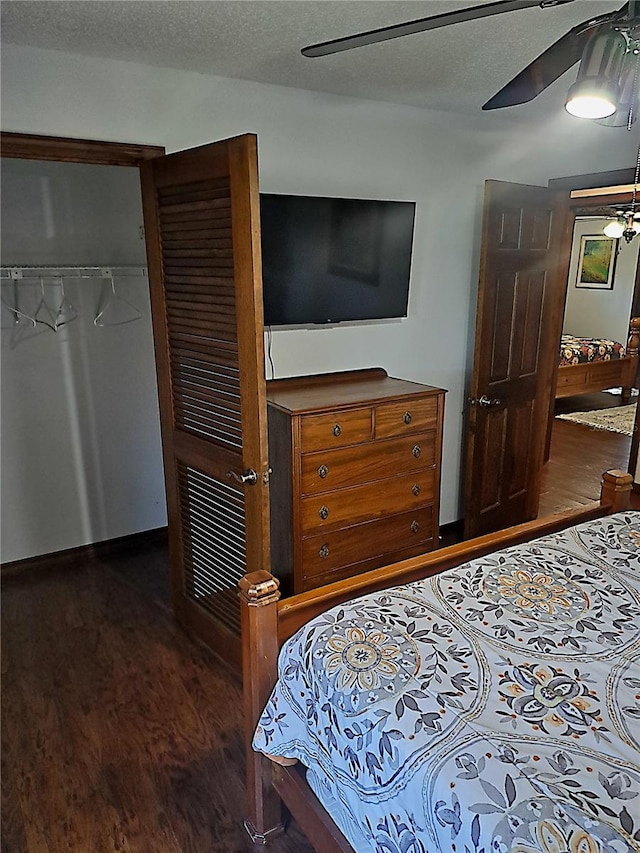 bedroom with a textured ceiling, ceiling fan, a closet, and wood finished floors