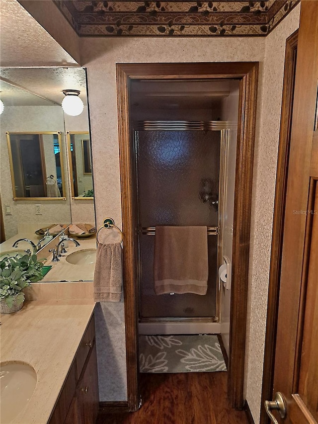 bathroom with a shower stall, wood finished floors, and vanity