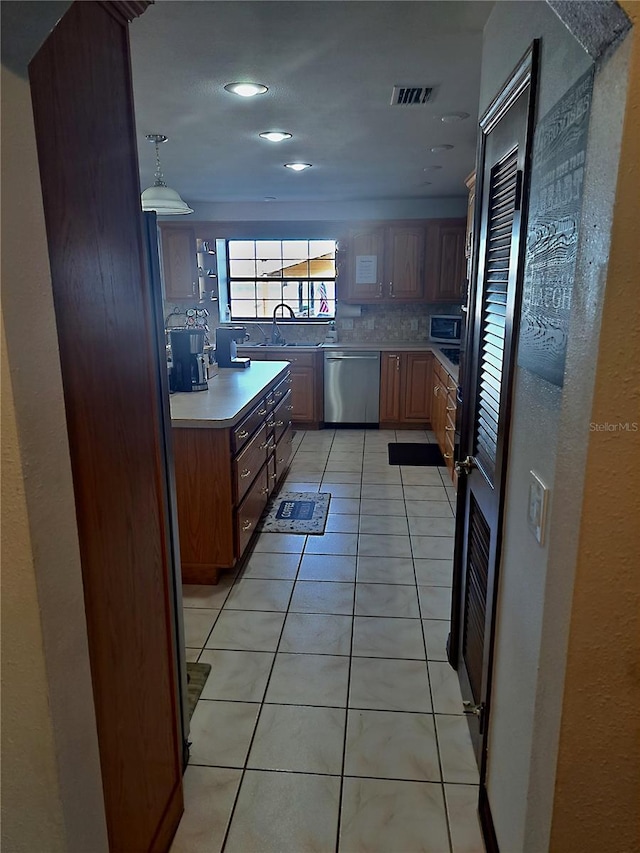 kitchen featuring stainless steel appliances, light countertops, visible vents, decorative backsplash, and light tile patterned flooring