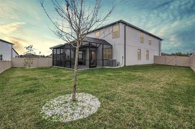 rear view of house featuring a gate, a fenced backyard, a yard, and central AC unit