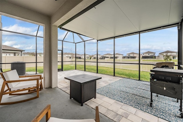 sunroom / solarium featuring plenty of natural light and a residential view