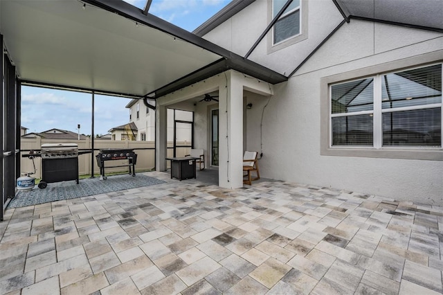 view of patio / terrace featuring glass enclosure, a ceiling fan, and area for grilling