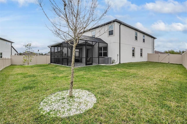 rear view of house with central AC unit, a lawn, a fenced backyard, and a gate