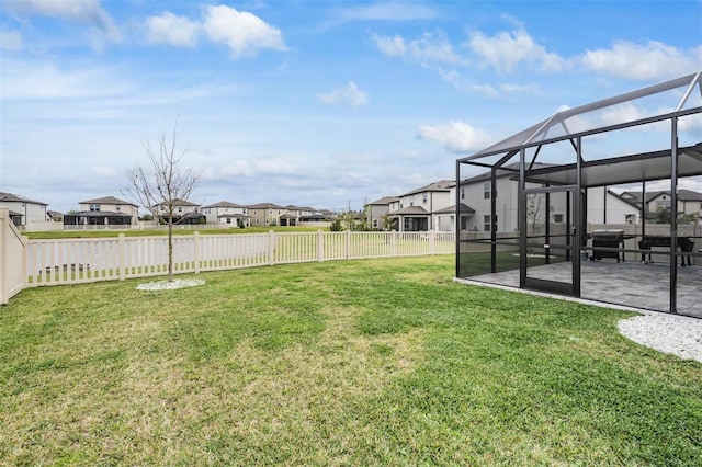 view of yard featuring glass enclosure, a fenced backyard, a residential view, and a patio