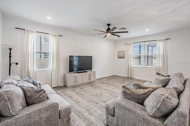 living area with visible vents, baseboards, a ceiling fan, light wood-style flooring, and recessed lighting