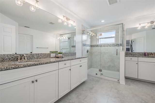 bathroom featuring a stall shower, vanity, and visible vents