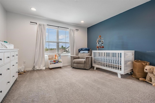 carpeted bedroom featuring a nursery area, baseboards, and recessed lighting