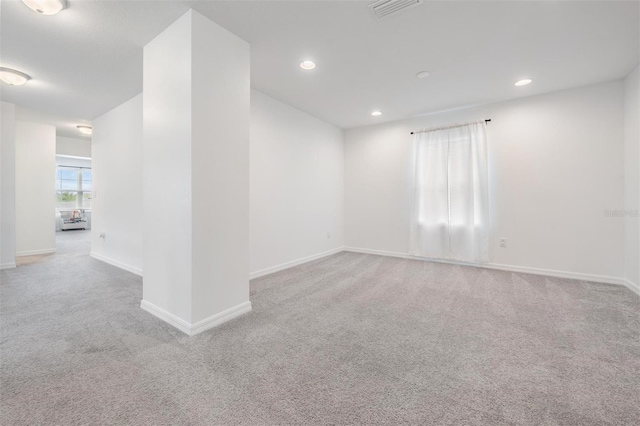 carpeted spare room with recessed lighting, visible vents, and baseboards