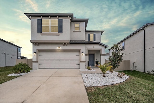 view of front of house with driveway, a garage, fence, a front lawn, and stucco siding