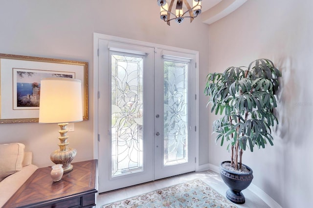 entrance foyer featuring french doors, a notable chandelier, plenty of natural light, and baseboards