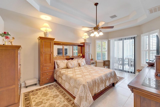 bedroom featuring light tile patterned floors, multiple windows, a raised ceiling, and visible vents