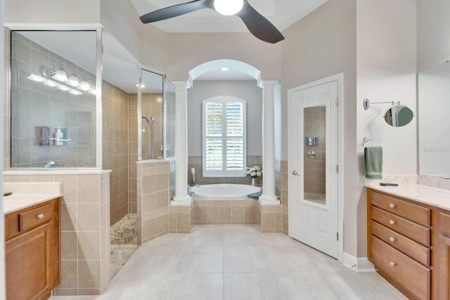 bathroom featuring a garden tub, vanity, tile patterned floors, walk in shower, and decorative columns