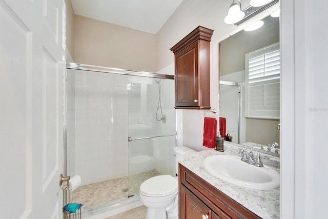 bathroom with toilet, a stall shower, and vanity