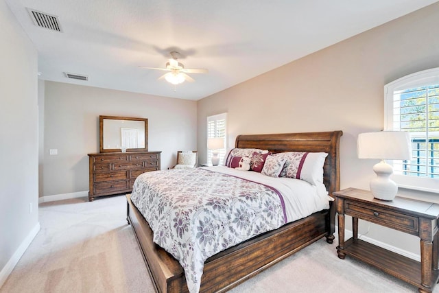 bedroom featuring a ceiling fan, visible vents, light carpet, and baseboards