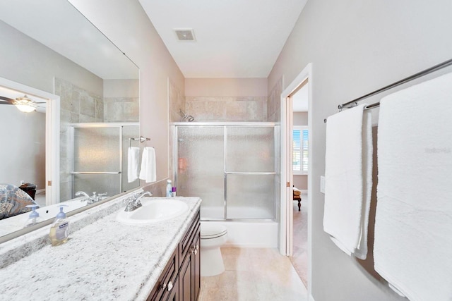 bathroom with visible vents, toilet, combined bath / shower with glass door, vanity, and tile patterned floors